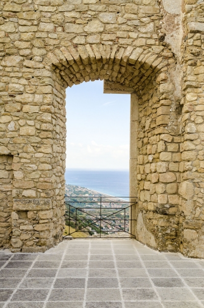 Ancient window among ruins of an old castle with seascape