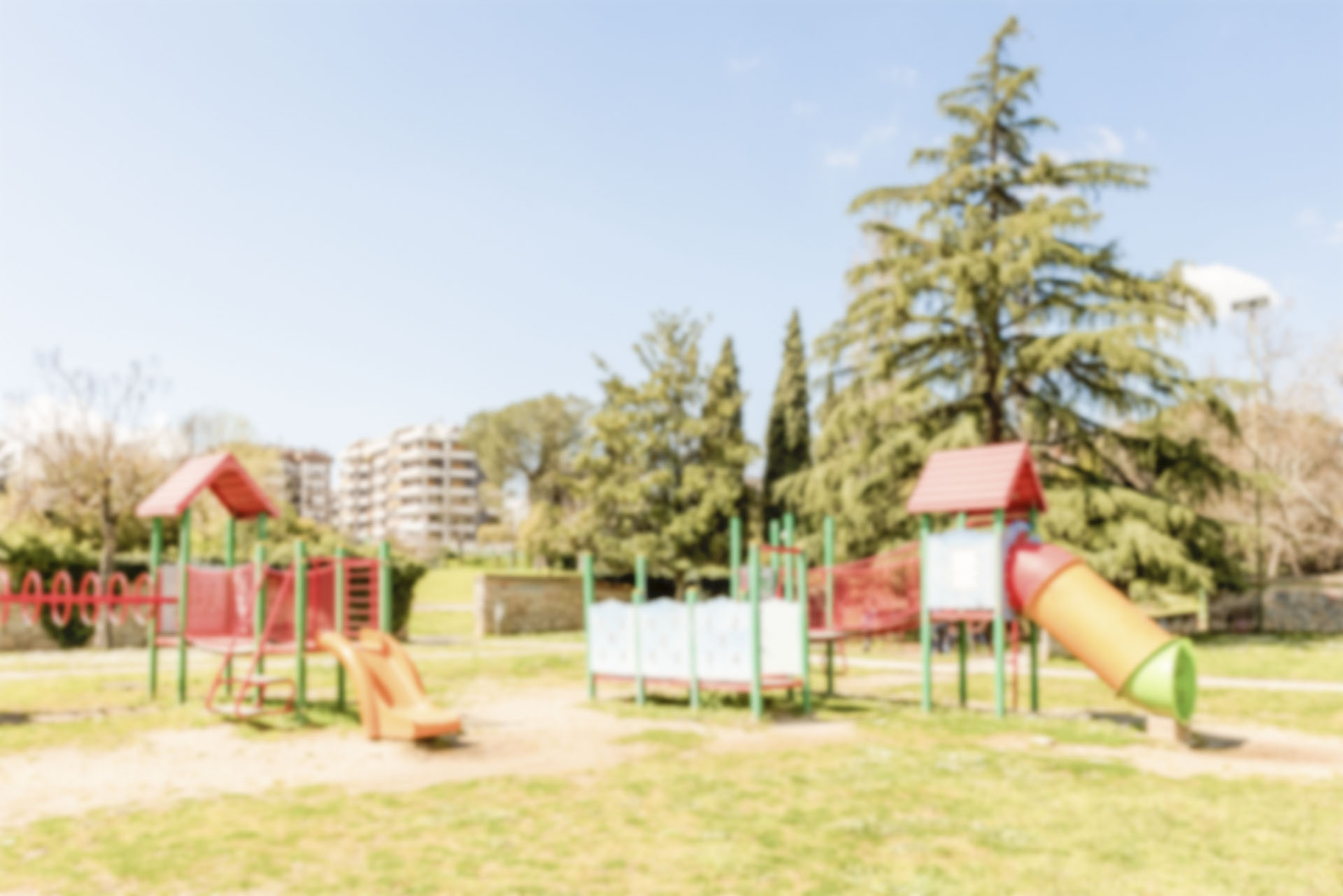 Defocused background of colorful playground for kids in public park