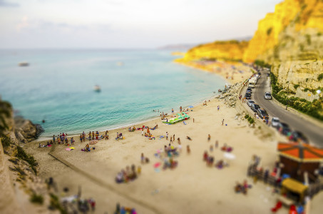 Aerial panoramic view of the beach at sunset in Tropea, Italy. Tilt-shift effect applied