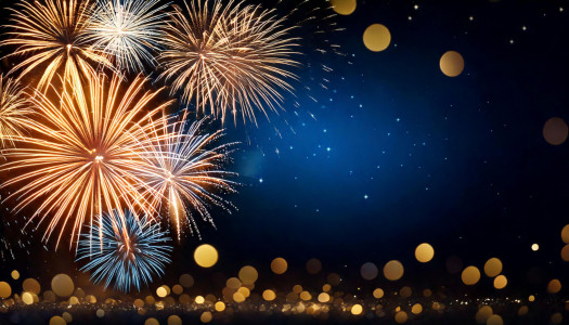Golden fireworks exploding over a sparkling bokeh background with copy space. AI-generated content